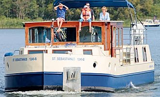 unsere Primus Kormoran auf einen See mit Bimini und einer Familie an Deck