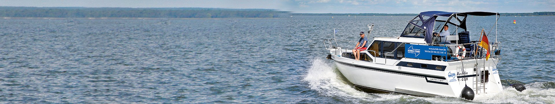 Das Hausboot Grund 33 besetzt mit einem Vater und seinem Sohn fährt flott über einen Dee.