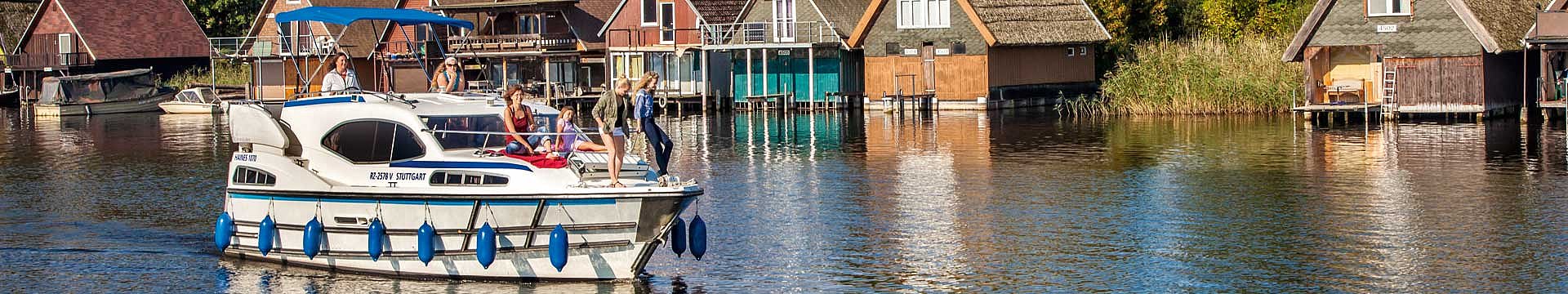 Die Haines 1070 fährt auf der Mecklenburgischen Seenplatte an nostalgischen Bootshäusern vorbei.