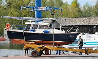 Ein Boot wird gekrant und zu Wasser gelassen.